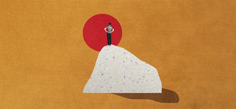 A man on top of a boulder